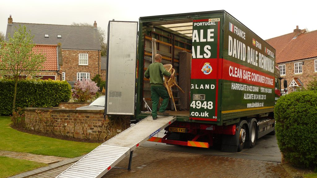 David Dale crew members loading carefully wrapped furniture pieces into a lorry in a residential driveway